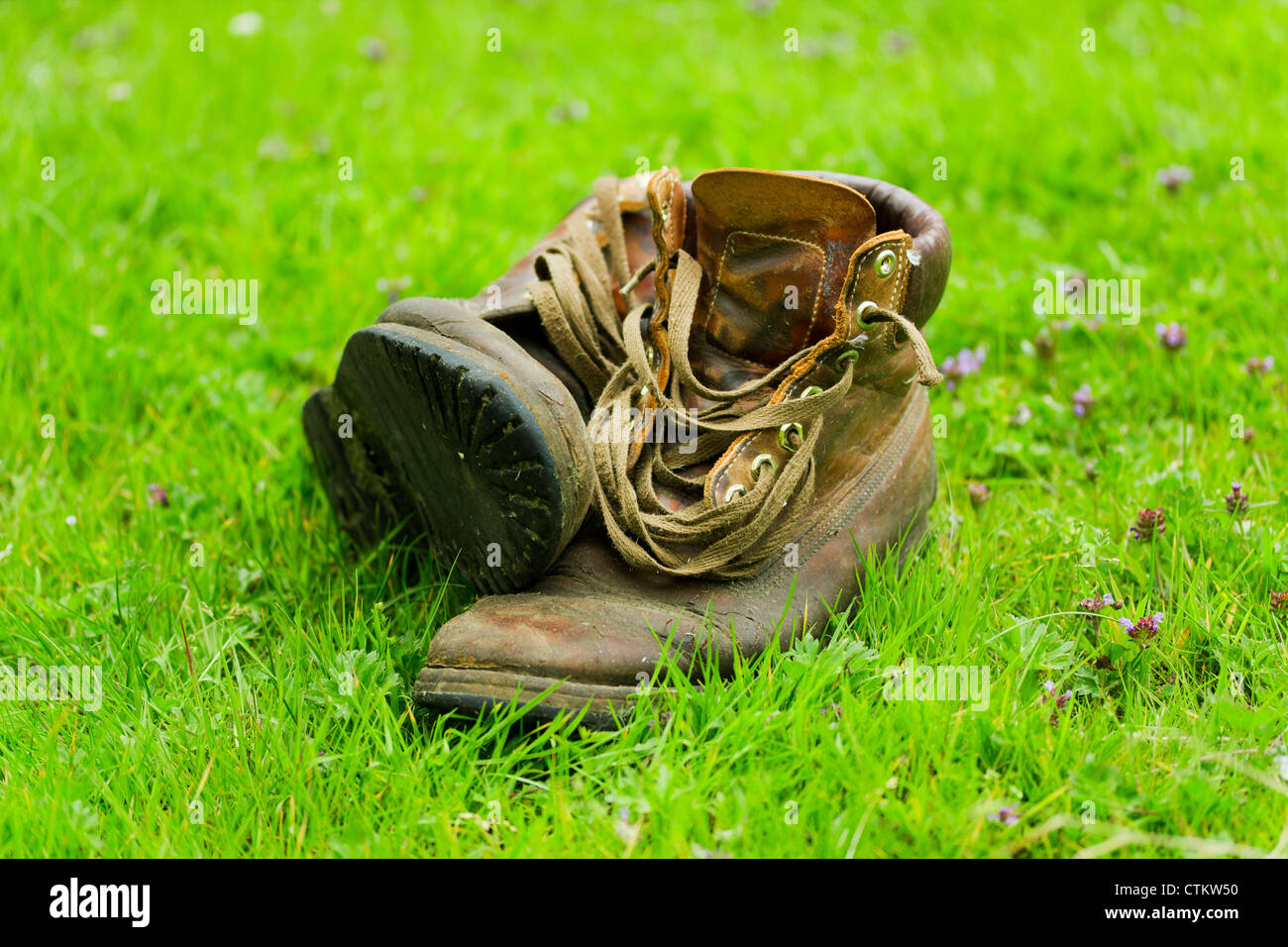 Pair of old worn boots in the grass Stock Photo