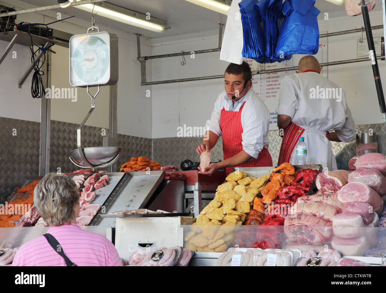 Butcher selling meat to customer Portsmouth street market England Stock
