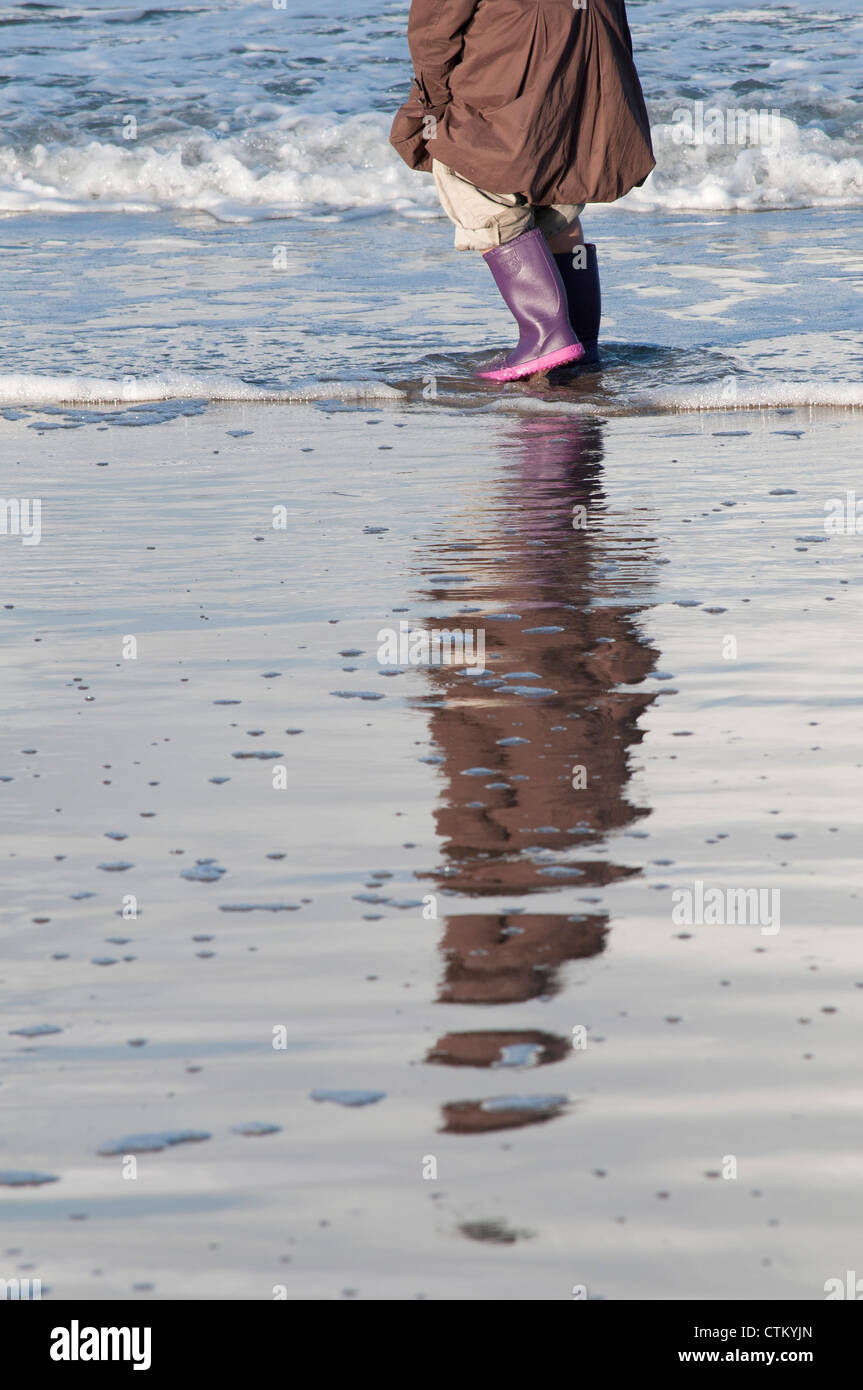 enfant courant sur une plage mouillée child running on a wet beach Stock Photo