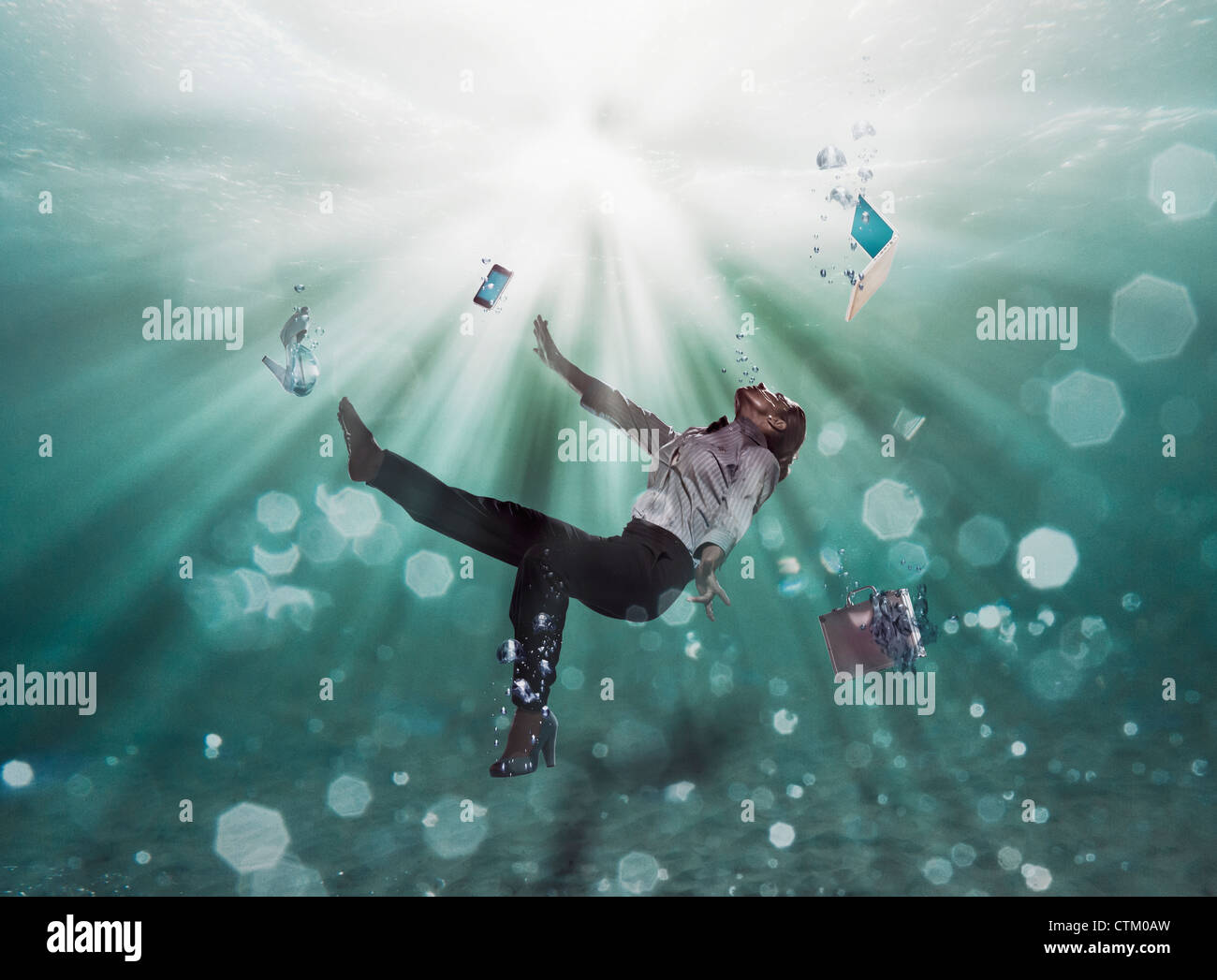 A Businesswoman Floating Underwater With Her Laptop Computer Cell Phone And Shoes; Cadiz, Spain Stock Photo