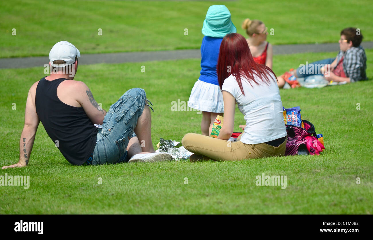 group of people enjoying a British summer picnic on the grass. Stock Photo