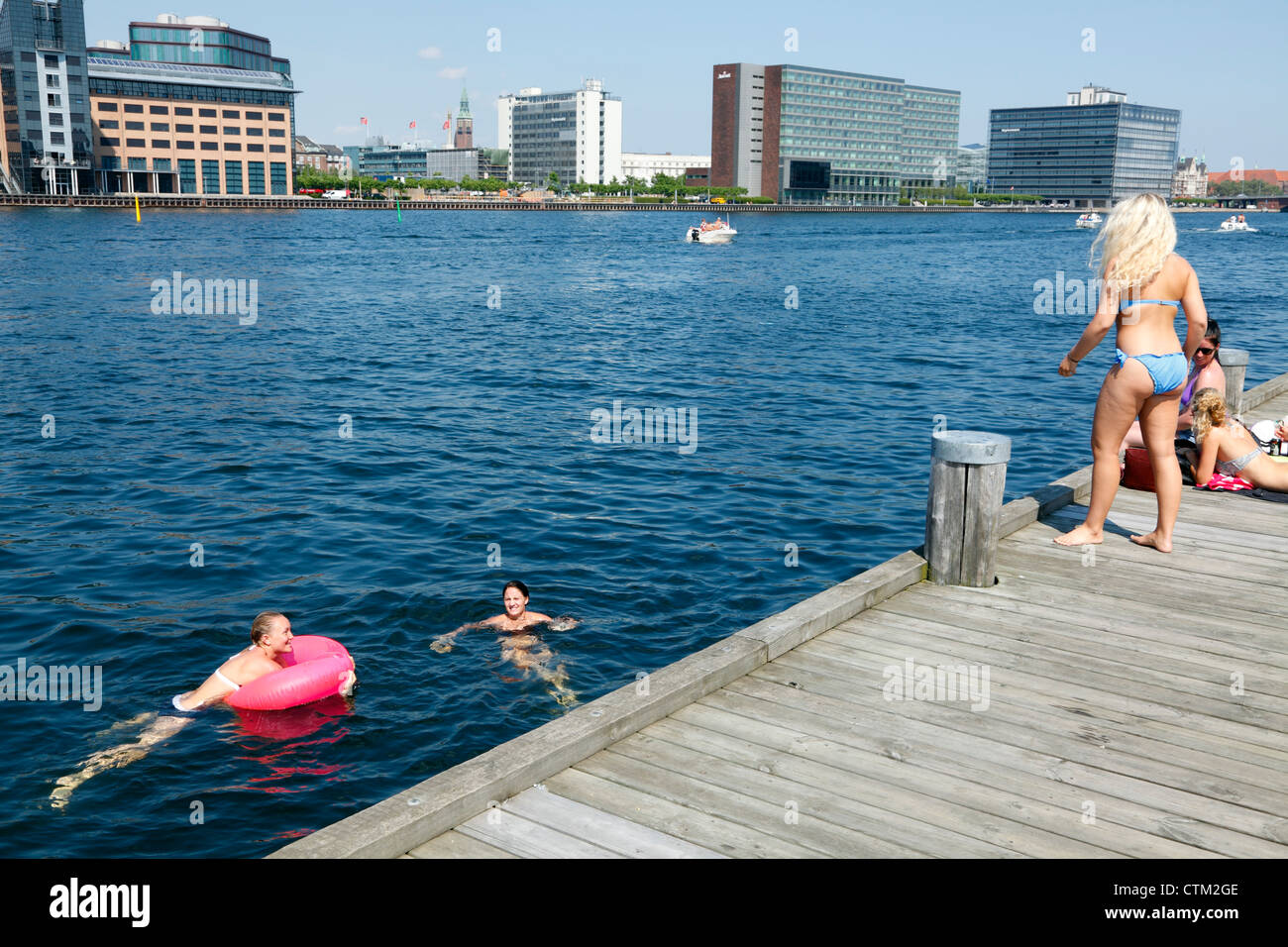 Girls sunbathing and bathing in the harbour from the Islands Brygge quay in  the port of Copenhagen, Denmark Stock Photo - Alamy