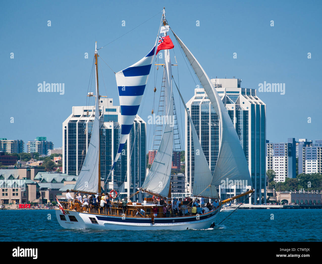 The tour boat Mar under sail with the Halifax, Nova Scotia, waterfront in the background Stock