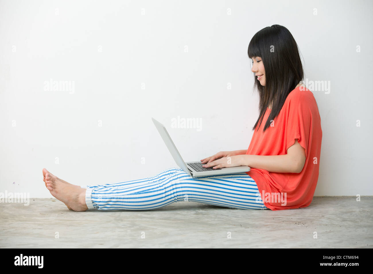 Young Asian girl sitting using laptop Stock Photo - Alamy