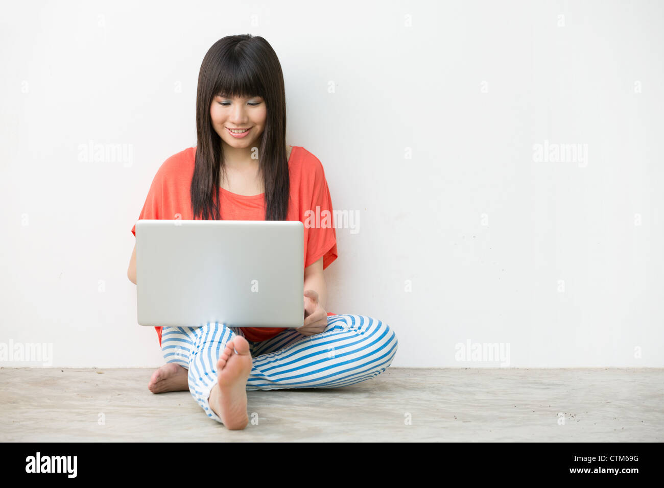 Young Asian girl sitting using laptop Stock Photo - Alamy