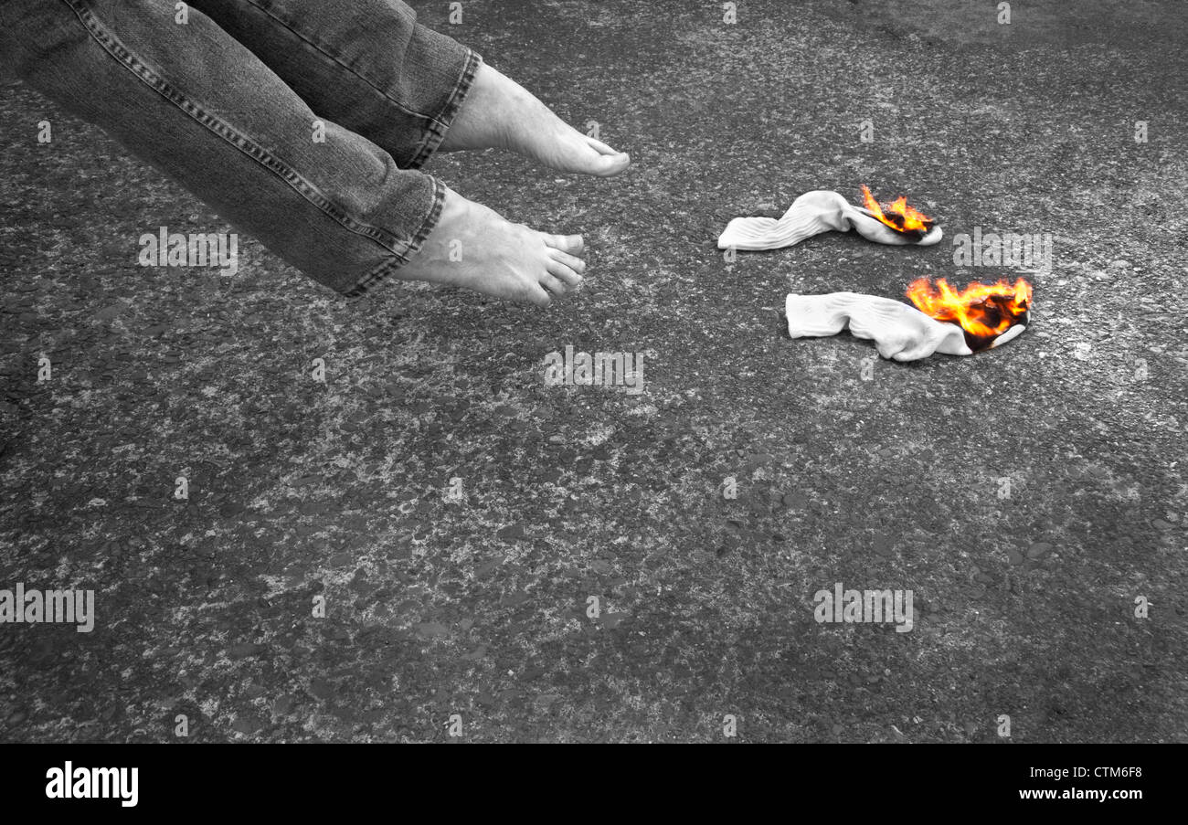 Two socks burning with two bare feet inches away. The flames are in
