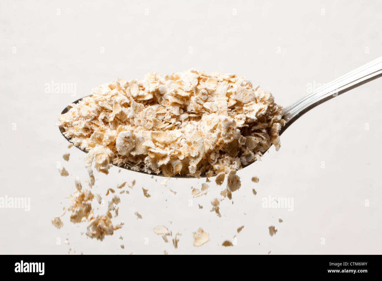 Spoon of oatmeal with some falling. Stock Photo