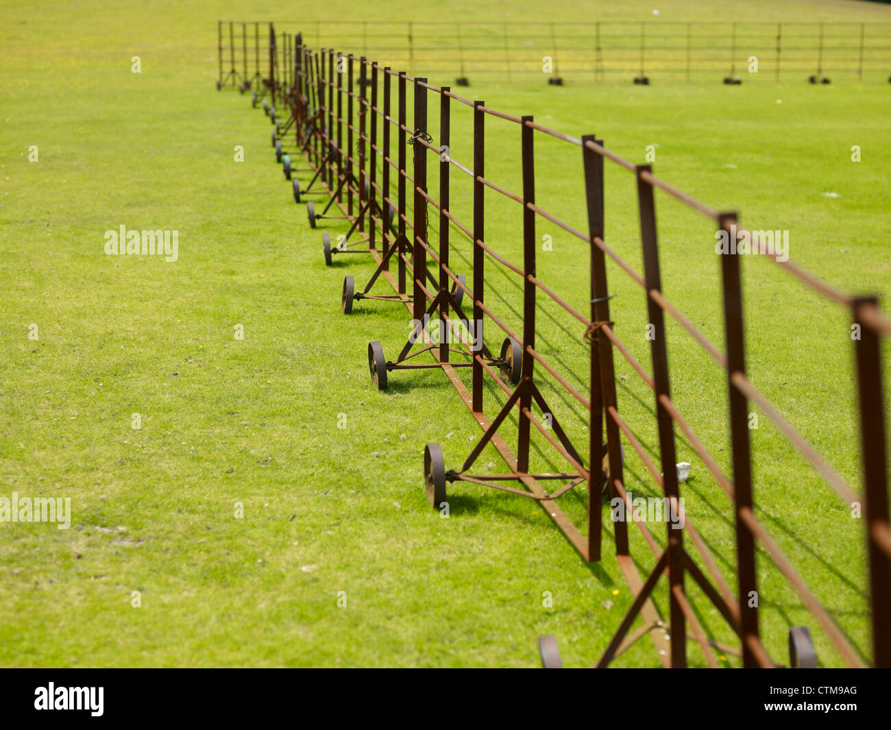 Cricket pitch protected from New Forest ponies by movable iron fencing Stock Photo