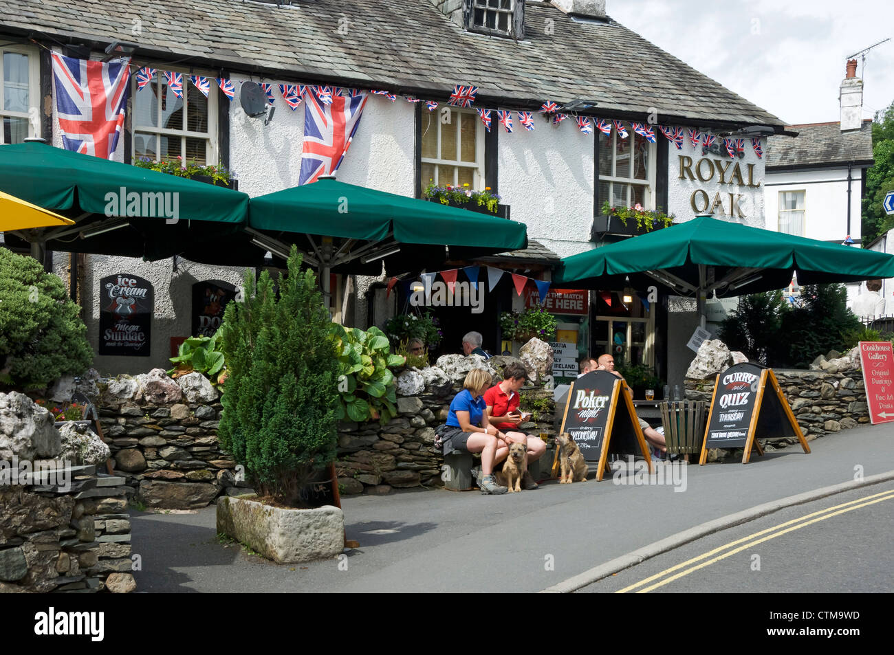 People sitting eating drinking outside the Royal Oak inn pub in summer