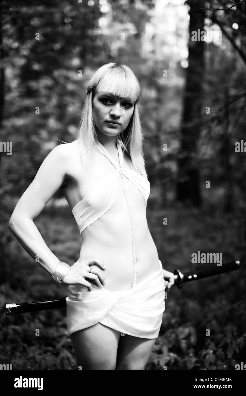 fantasy blond woman with sword at forest Stock Photo