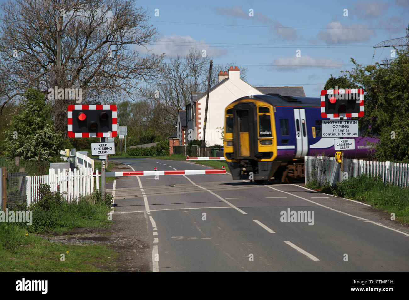 train at half barriers train crossing Stock Photo