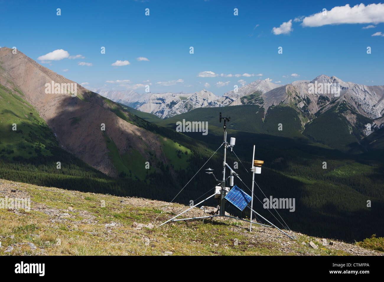 A Weather Station On Top Of A Ridge With Mountains And Valley In The Distance And Blue Sky With Clouds; Alberta, Canada Stock Photo