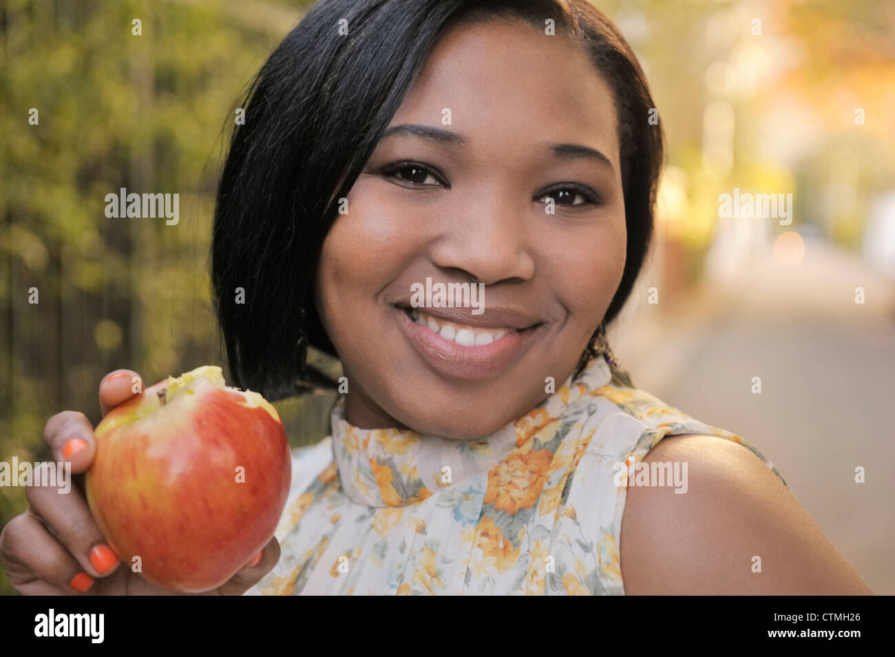 Young woman smiling eating an apple, Cape Town, Western Cape Province, South Africa Stock Photo