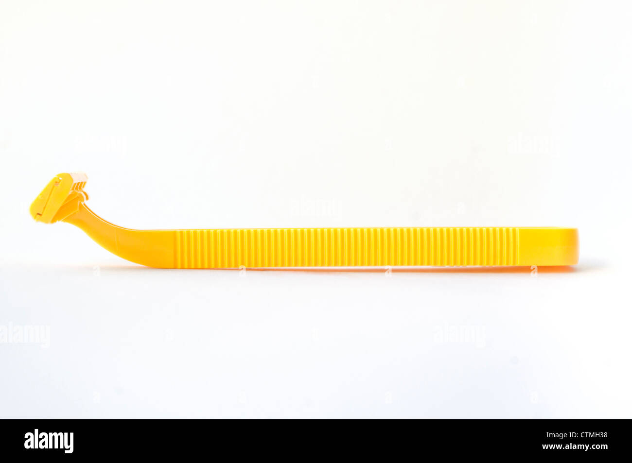 sideview of isolated disposable yellow razor, for men personal grooming concepts. Stock Photo