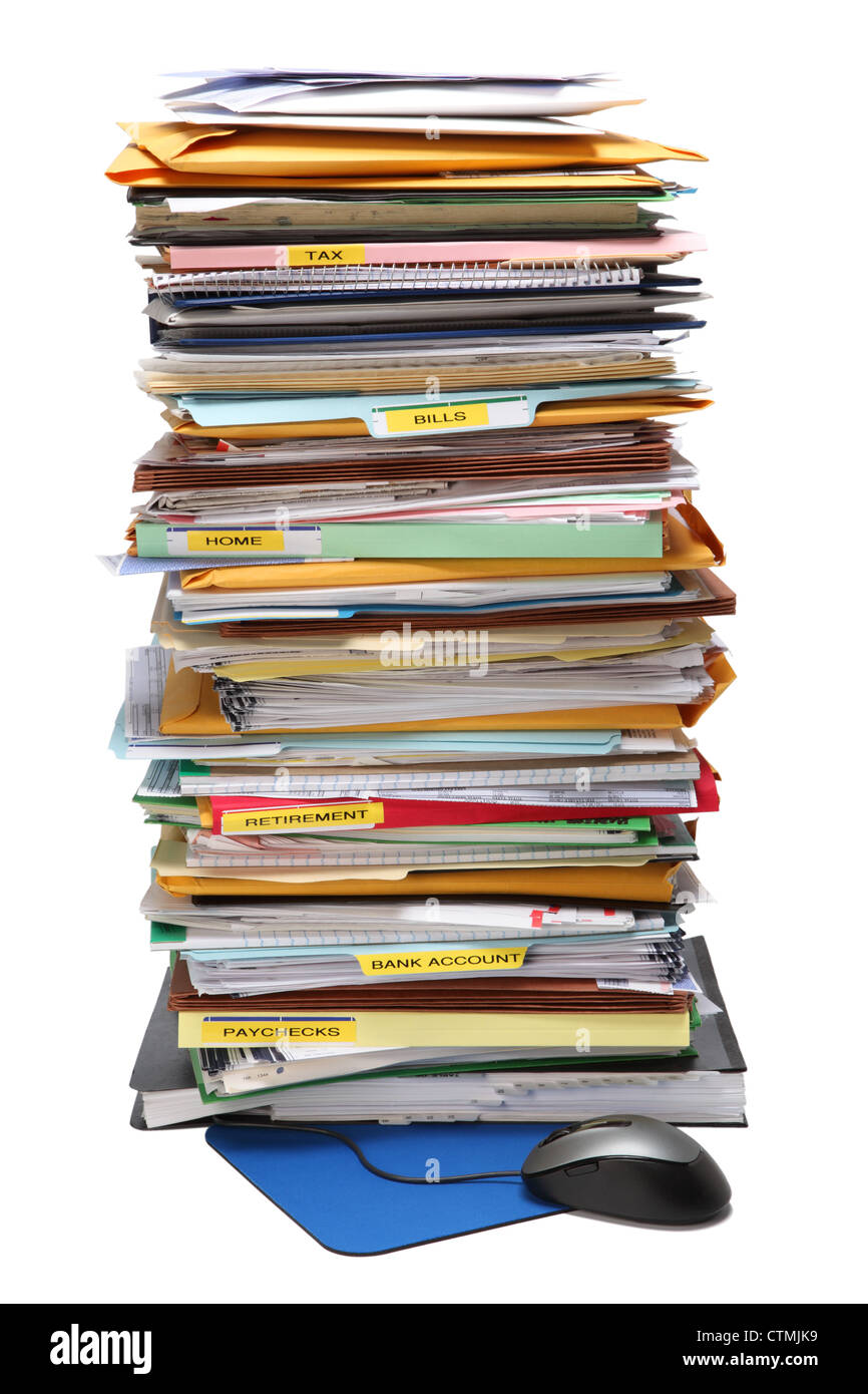 A very tall stack of paperwork in color folders. A Computer mouse and