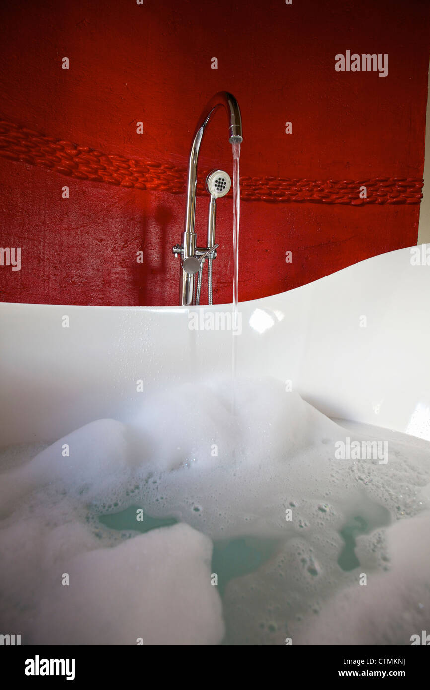 A low angle view tap running into a bath full of bubbles Pondoro Game Lodge Balule Private Nature Reserve, Limpopo South Africa Stock Photo