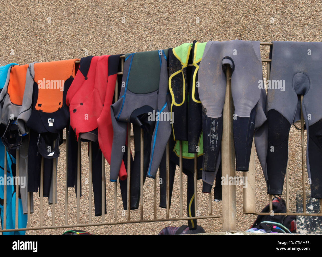 Wetsuits hanging over a rail to dry, Cornwall, UK Stock Photo Alamy