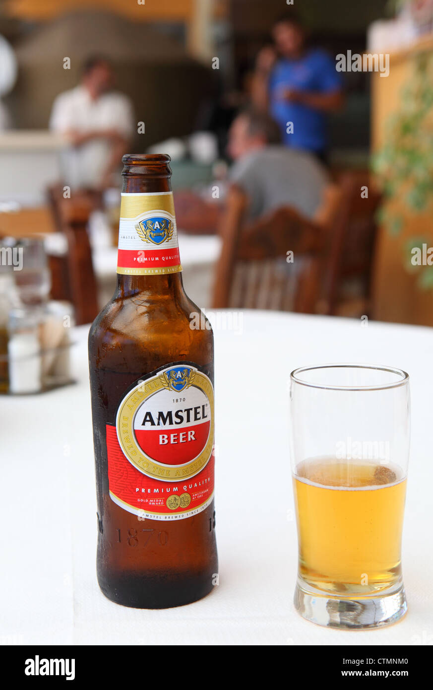 A bottle and glass of Amstel lager beer in a Greek taverna in Rethymno, Crete Stock Photo