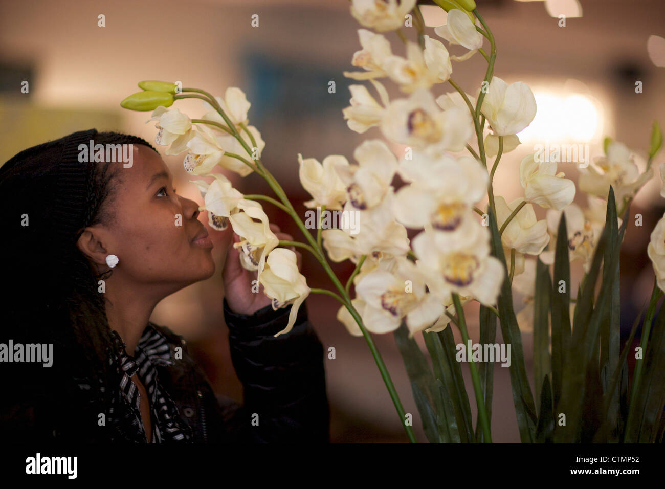 A young woman smelling flowers, Pietermaritzburg, KwaZulu-Natal, South Africa Stock Photo