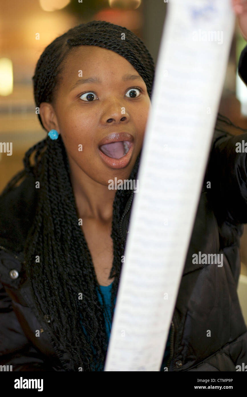 A young woman looking at her bill, Pietermaritzburg, KwaZulu-Natal, South Africa Stock Photo