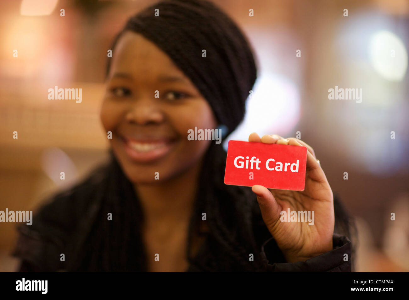 A young woman holding up a red gift card, Pietermaritzburg, KwaZulu-Natal, South Africa Stock Photo