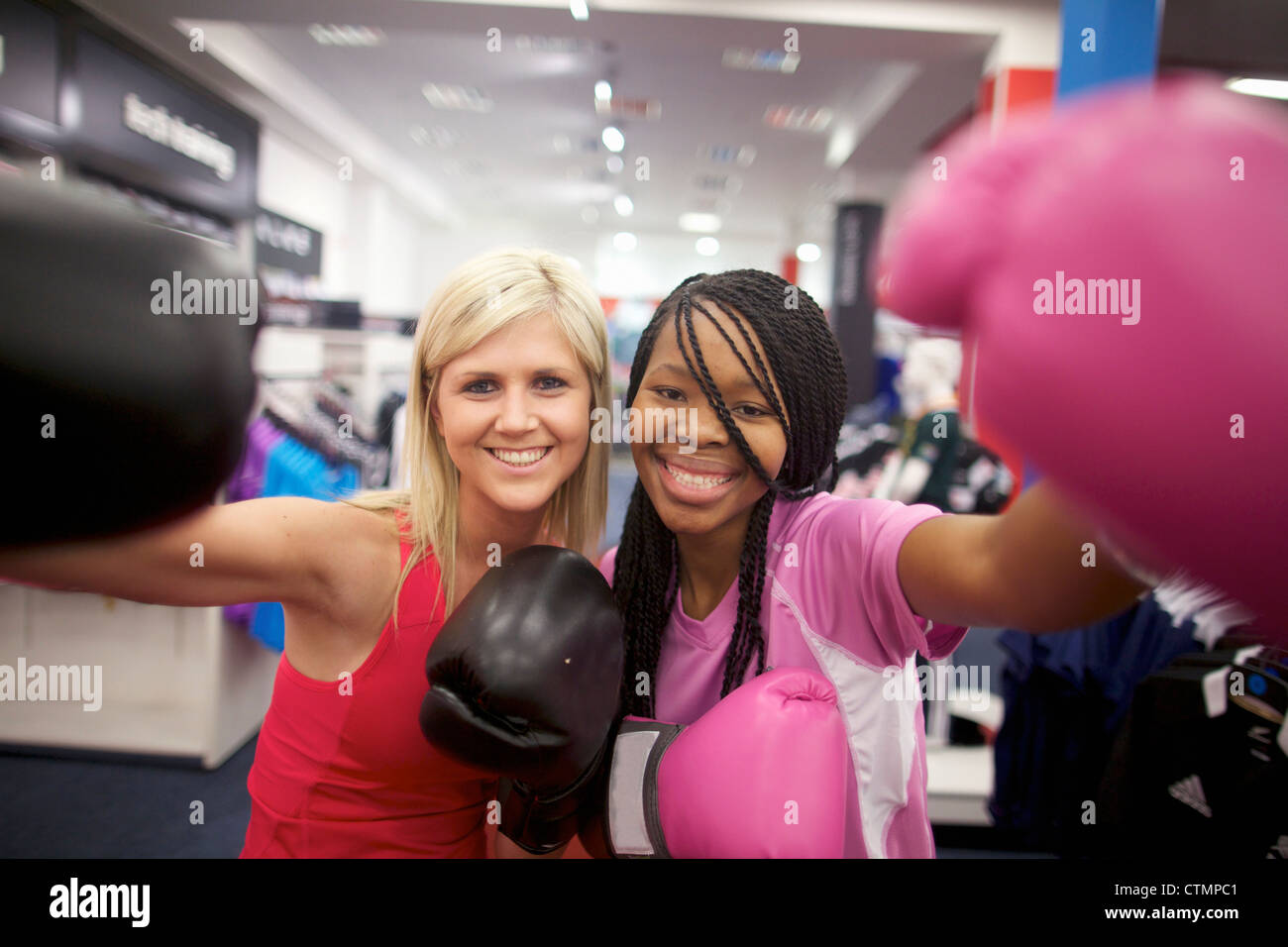 Two young women wearing boxing gloves and looking at the camera, Pietermaritzburg, KwaZulu-Natal, South Africa Stock Photo