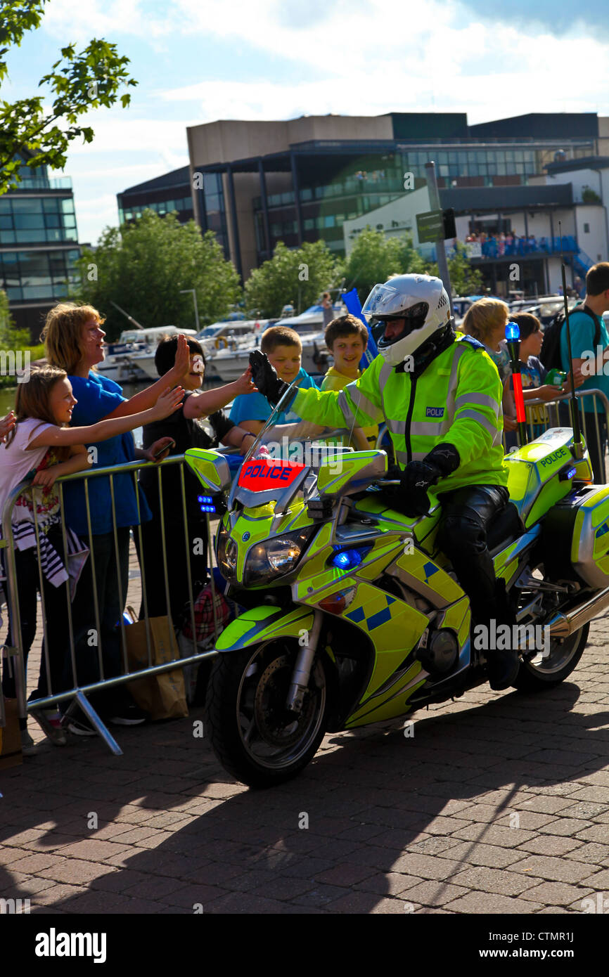 Police motorcycle rider gives high fives (5's) to the crowd lined to ...