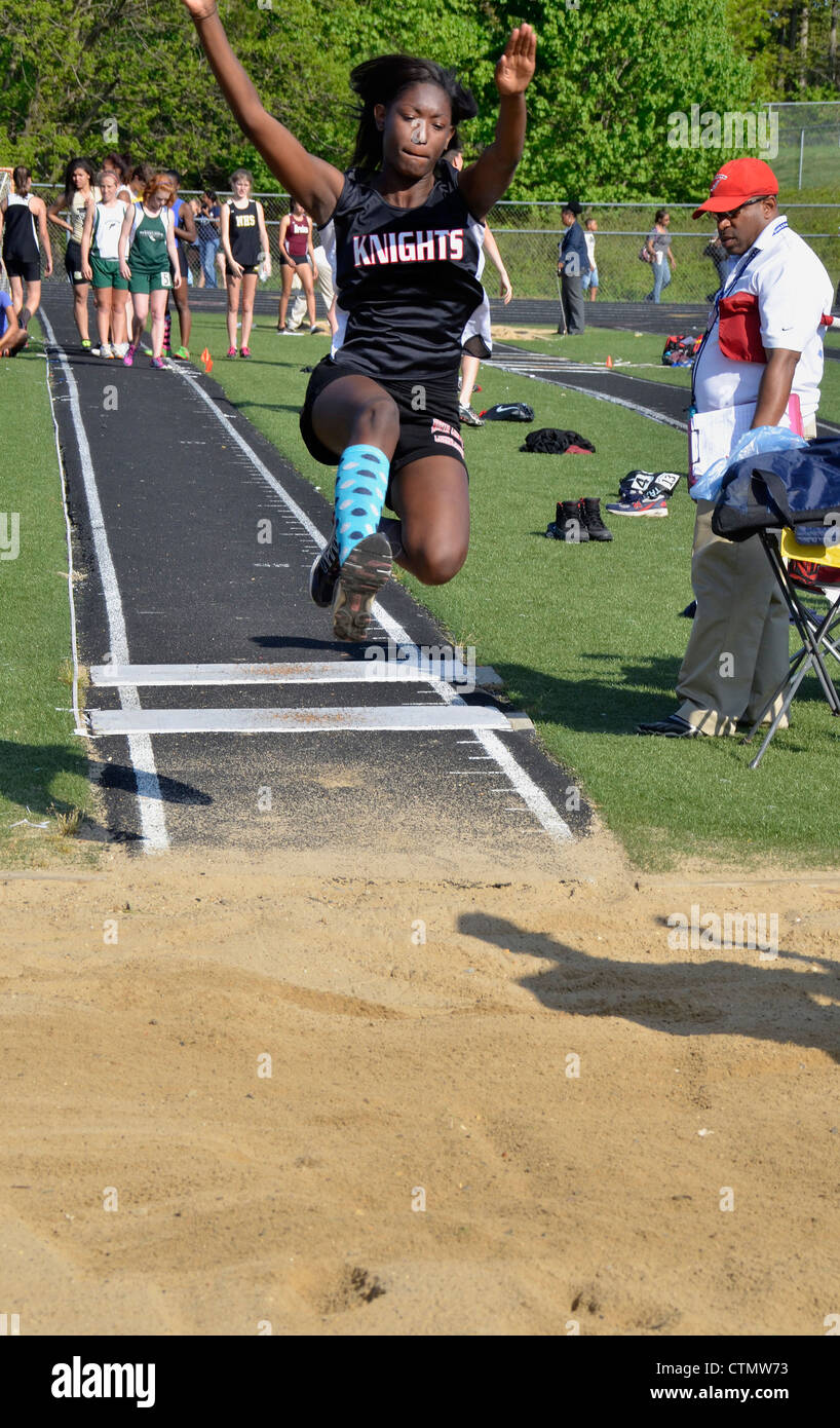 teen doing a high jump during a high school track and field event in