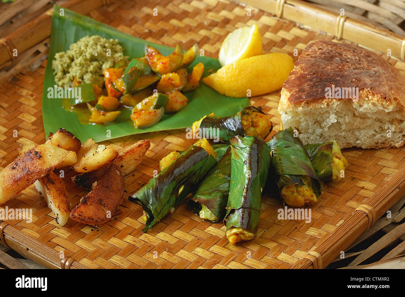 Indian cooking. Baked fish in banana leaves served with golden potatoes