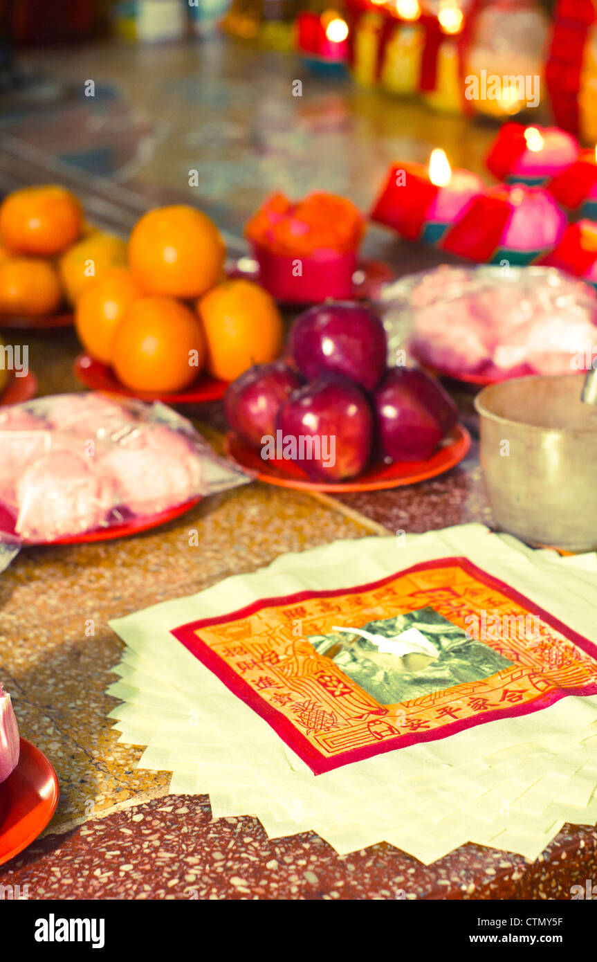 a close up shoot of fruits offerings and joss paper for taoism rituals. Stock Photo