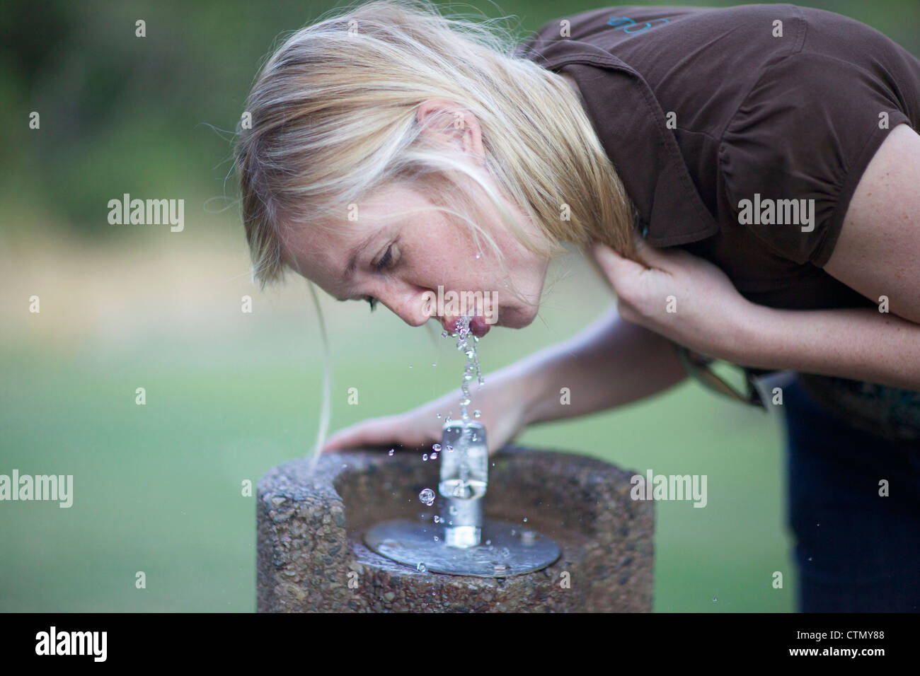 Woman drinking water from drinking fountain, Walter Sisulu Botanical Gardens, Johannesburg, Gauteng, South Africa Stock Photo