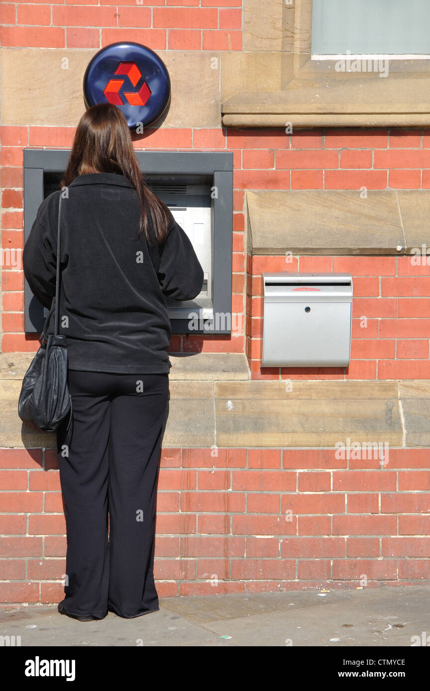 woman using ATM, Natwest, Whitby, North Yorkshire, England, UK Stock Photo