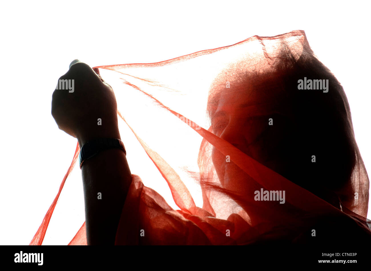 A silhoutte picture of Indian woman covering her face with saree Stock Photo