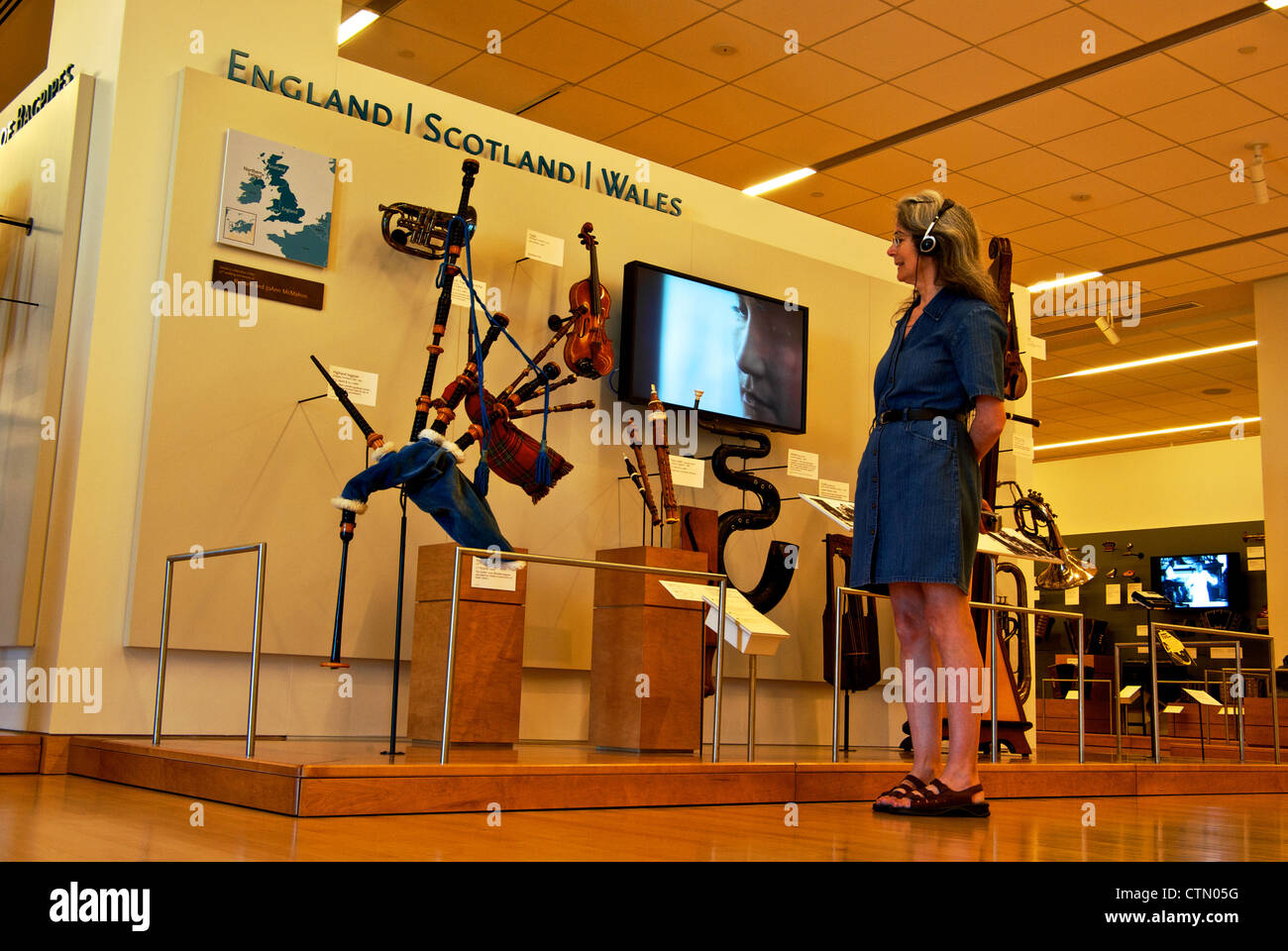 Woman examining England Scotland Wales bagpipe display Musical Instrument Museum Scottsdale AZ Stock Photo