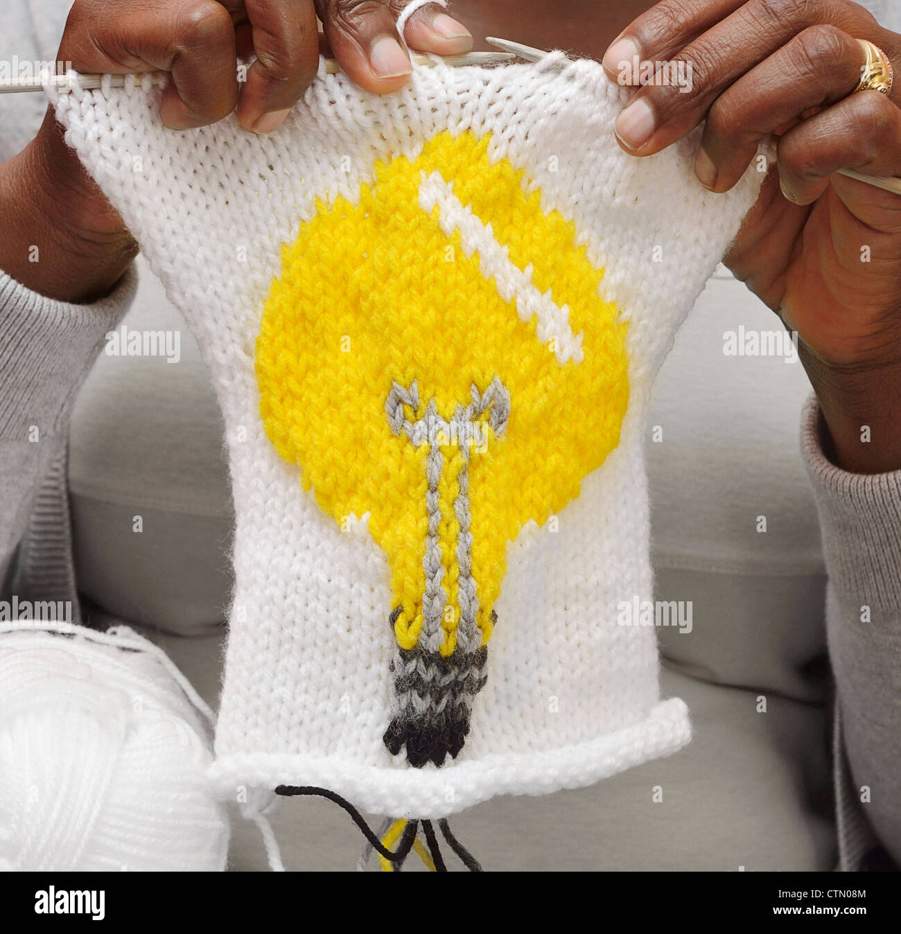 Hands knitting an image of a light bulb, Mandalay, Cape Town Stock Photo