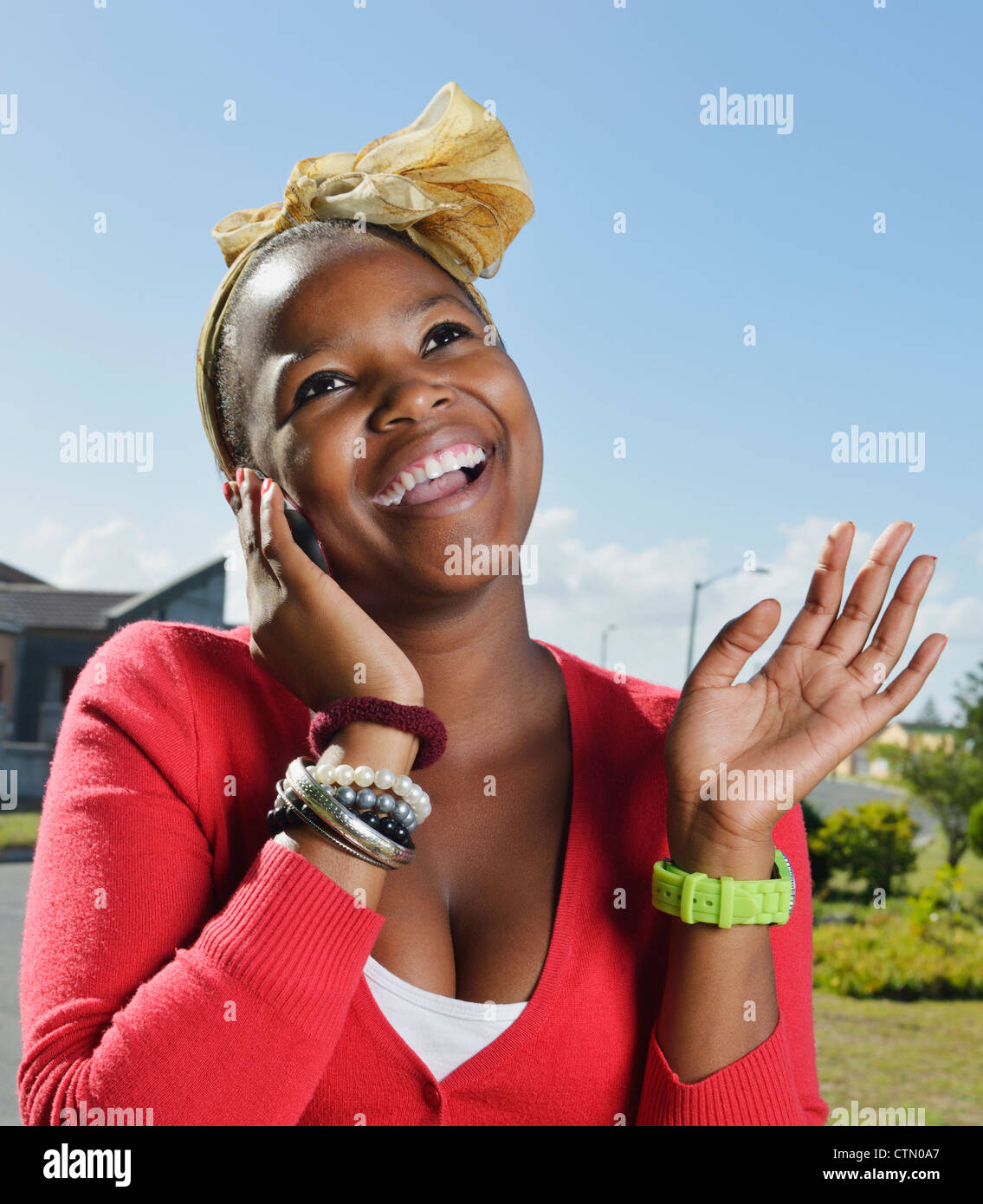Funky young woman laughing while using her phone, Mandalay, Cape Town Stock Photo