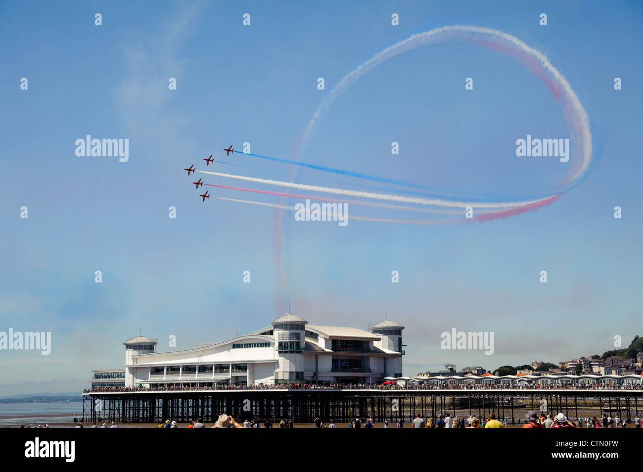 The Red Arrows perform a maneuver above the Grand Pier at Weston Super Mare. Stock Photo
