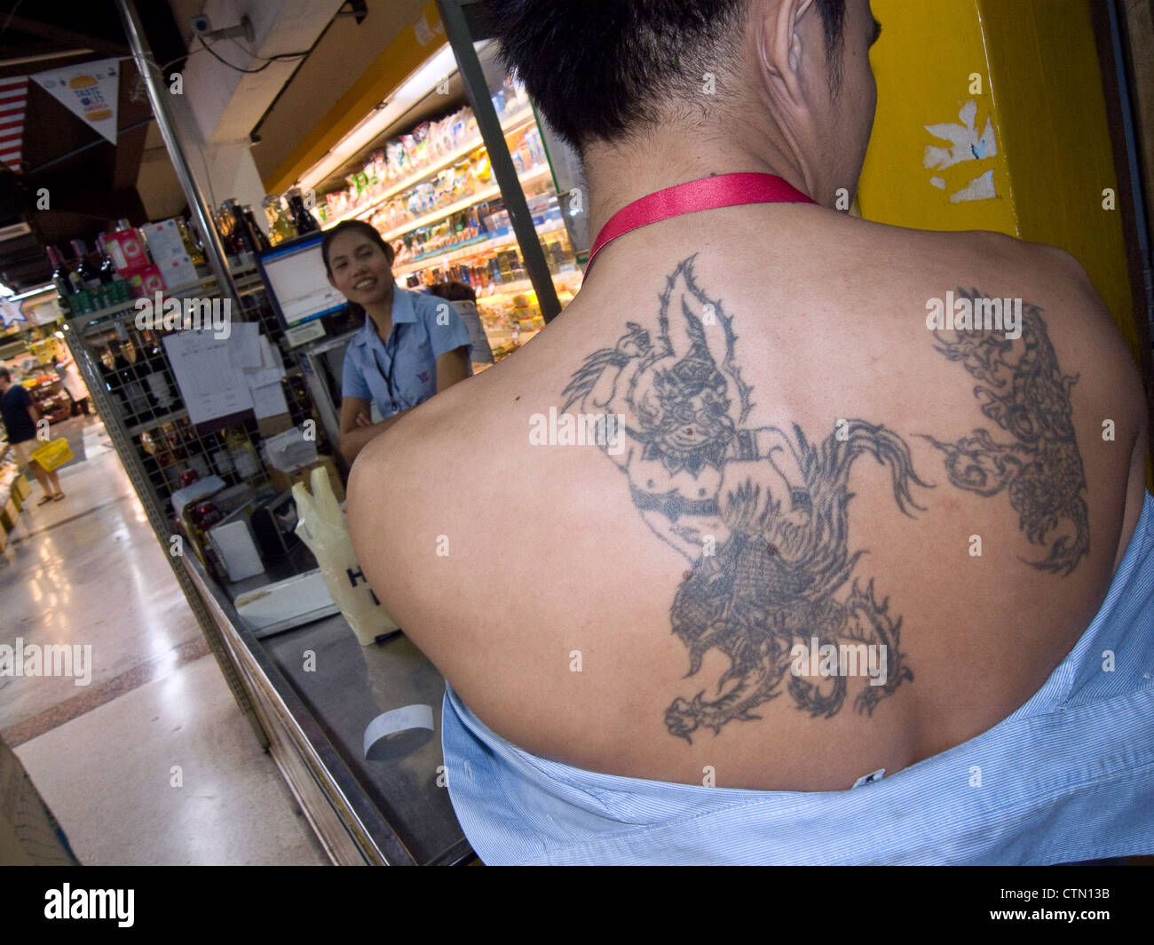 Sak Yan 'Sacred Tattoos' in Thailand. Supermarket worker. Bangkok. Stock Photo