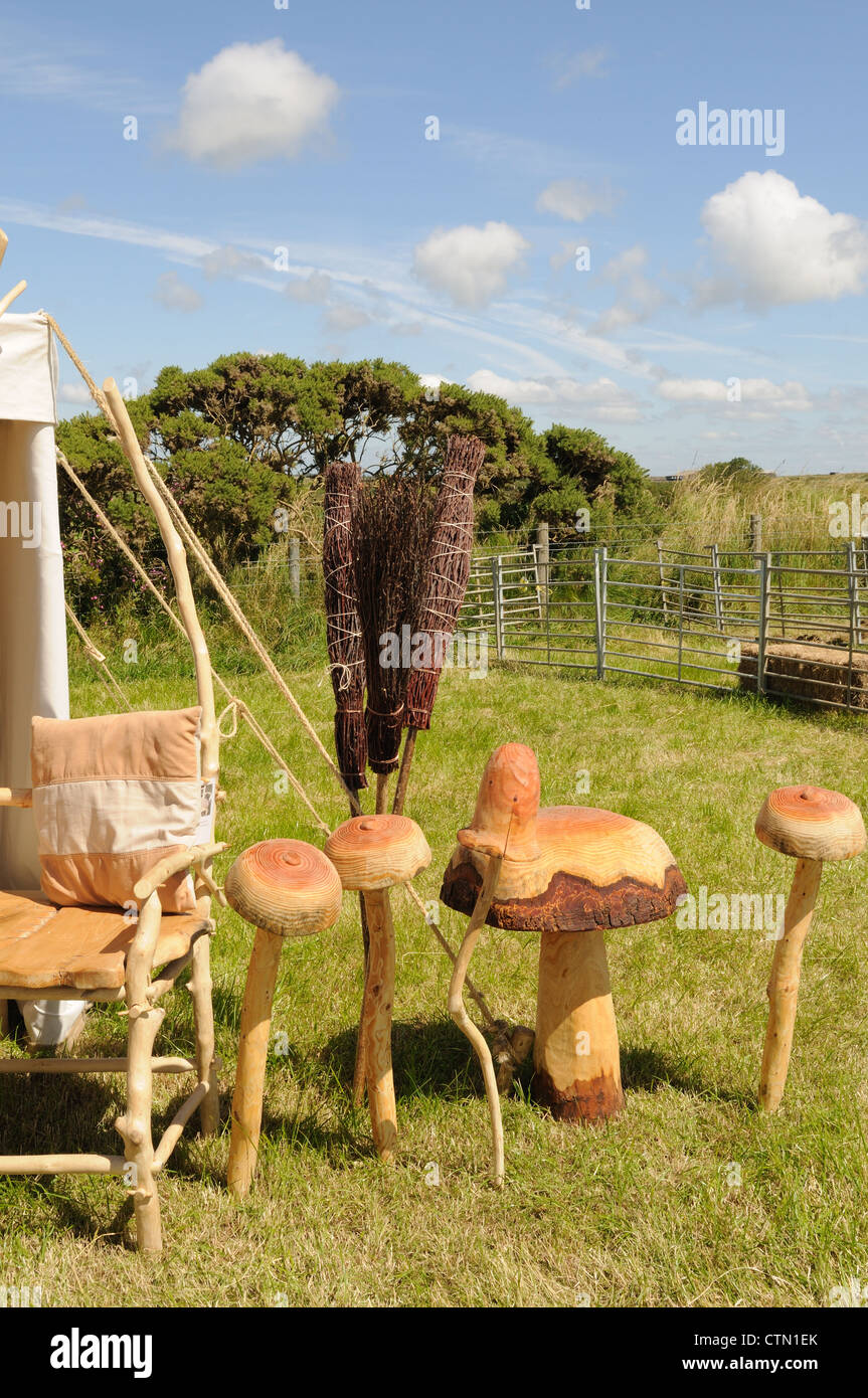Wooden carved mushrooms and Besom brooms for sale at a country Fair Pembrokeshire Wales Cymru UK GB Stock Photo