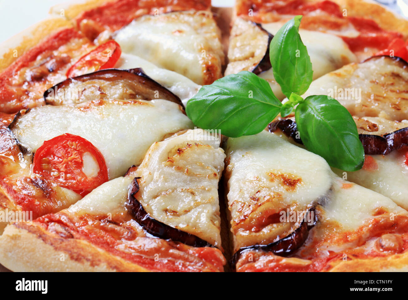 Pizza topped with cheese and slices of eggplant Stock Photo