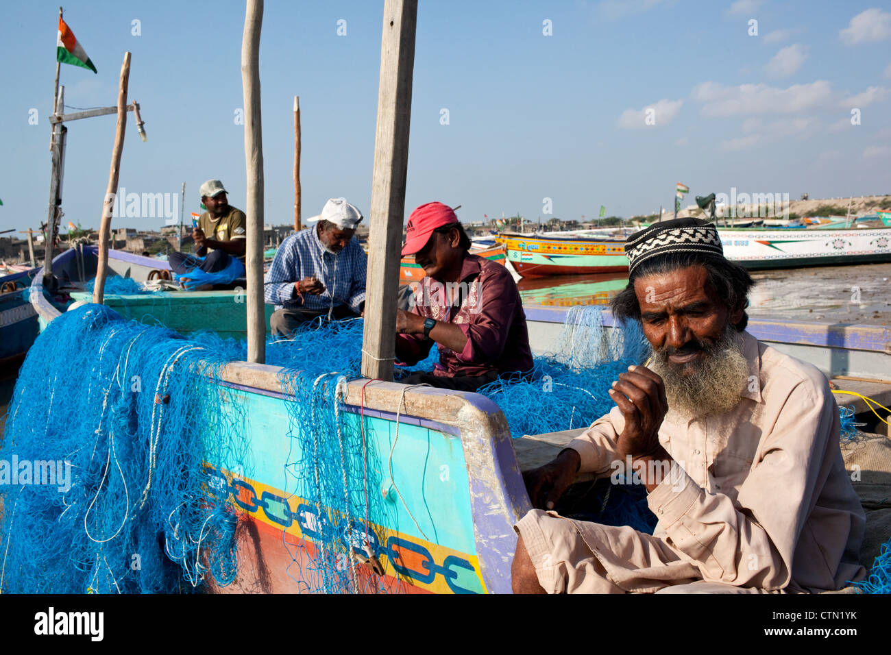 Fishermen at work fixing their fishing nets in a boat in a harbour near