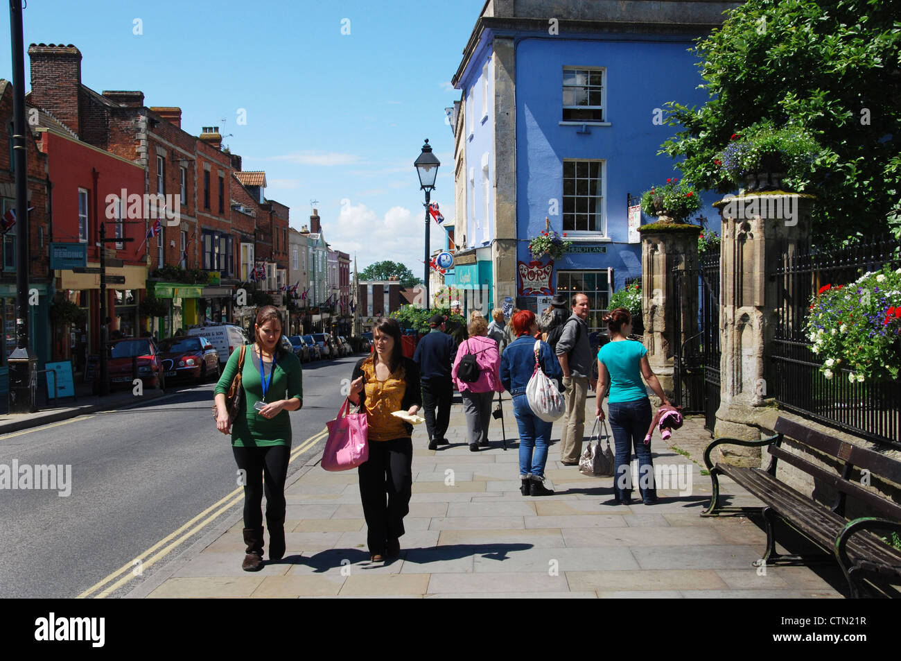 Colourful people in Glastonbury High Street Somerset England Stock Photo