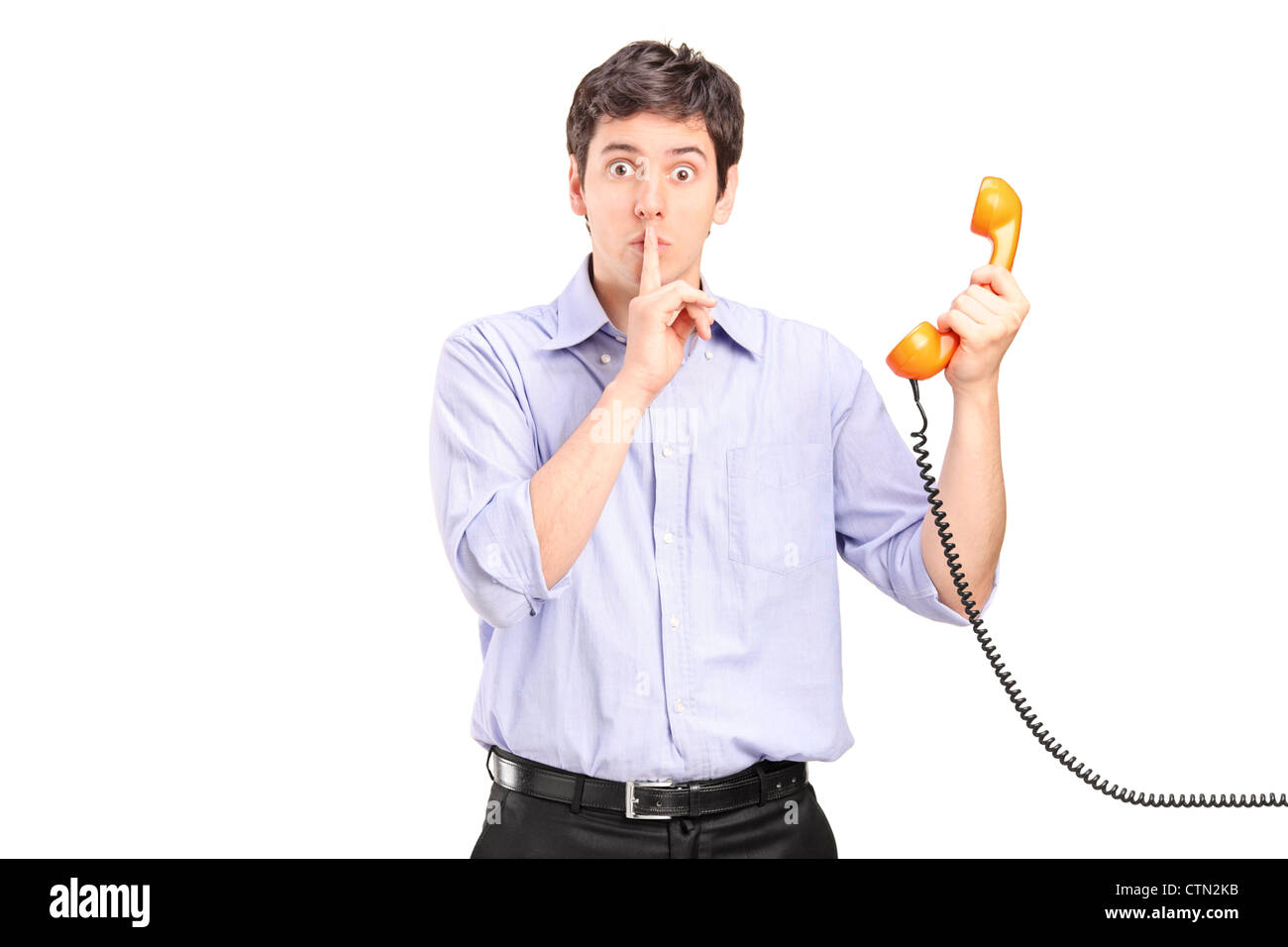 A man holding a telephone and gesturing silence isolated on white background Stock Photo