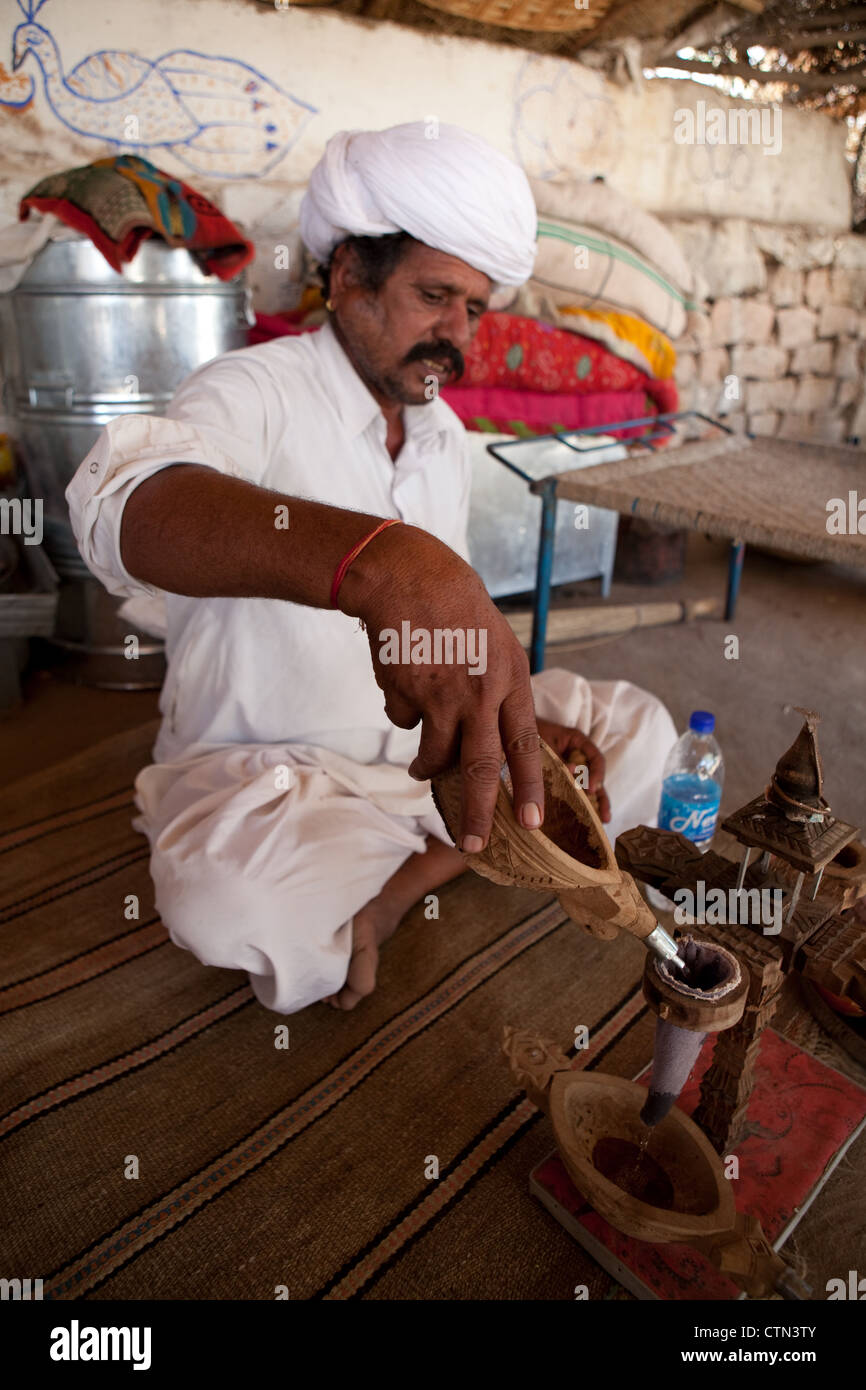 Indian man in turban preparing opium for tourists Stock Photo