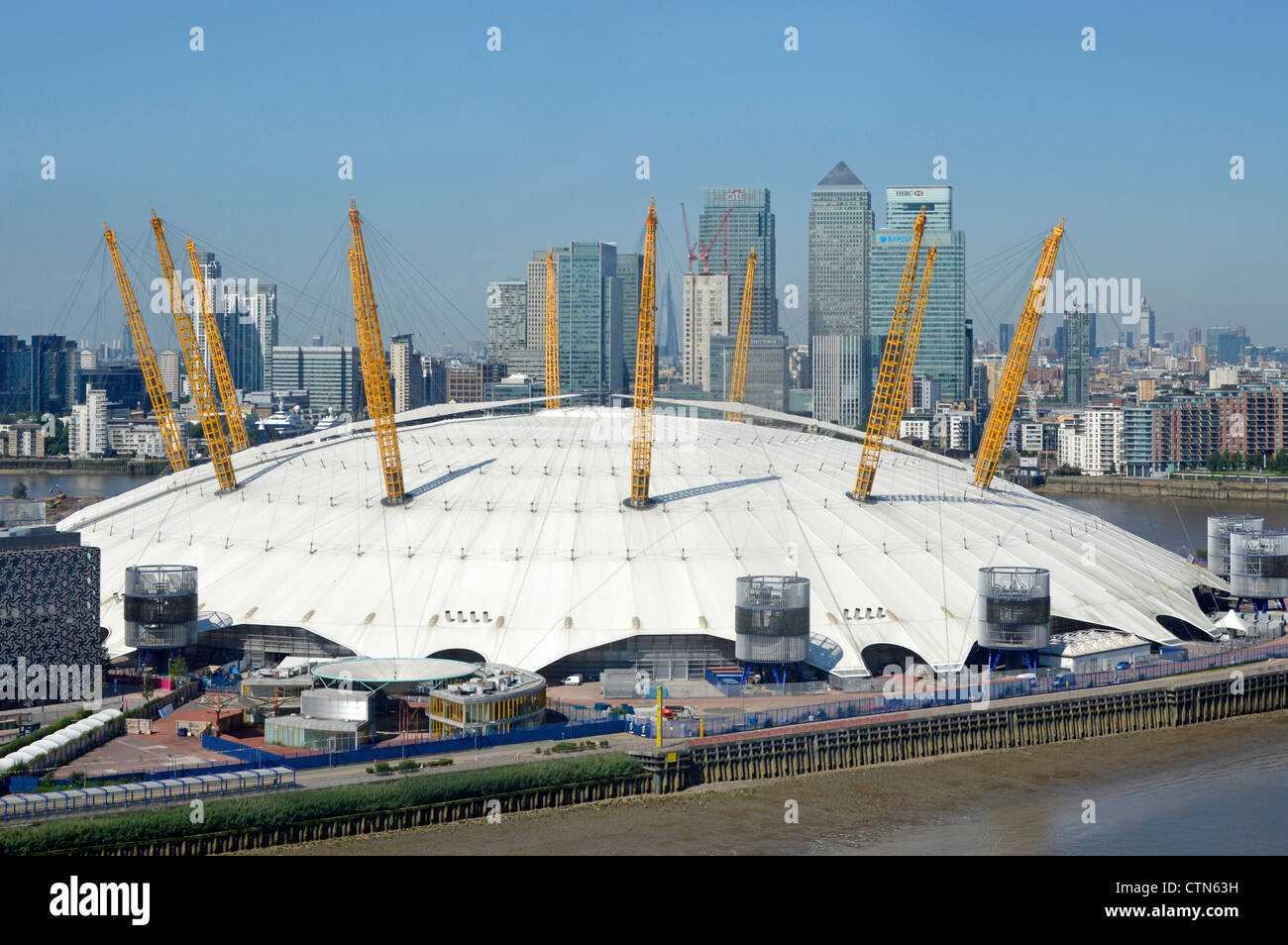 Aerial view O2 dome arena roof of London 2012 Olympic venue on the Greenwich Peninsula with Canary Wharf banking skyscraper skyline beyond England UK Stock Photo
