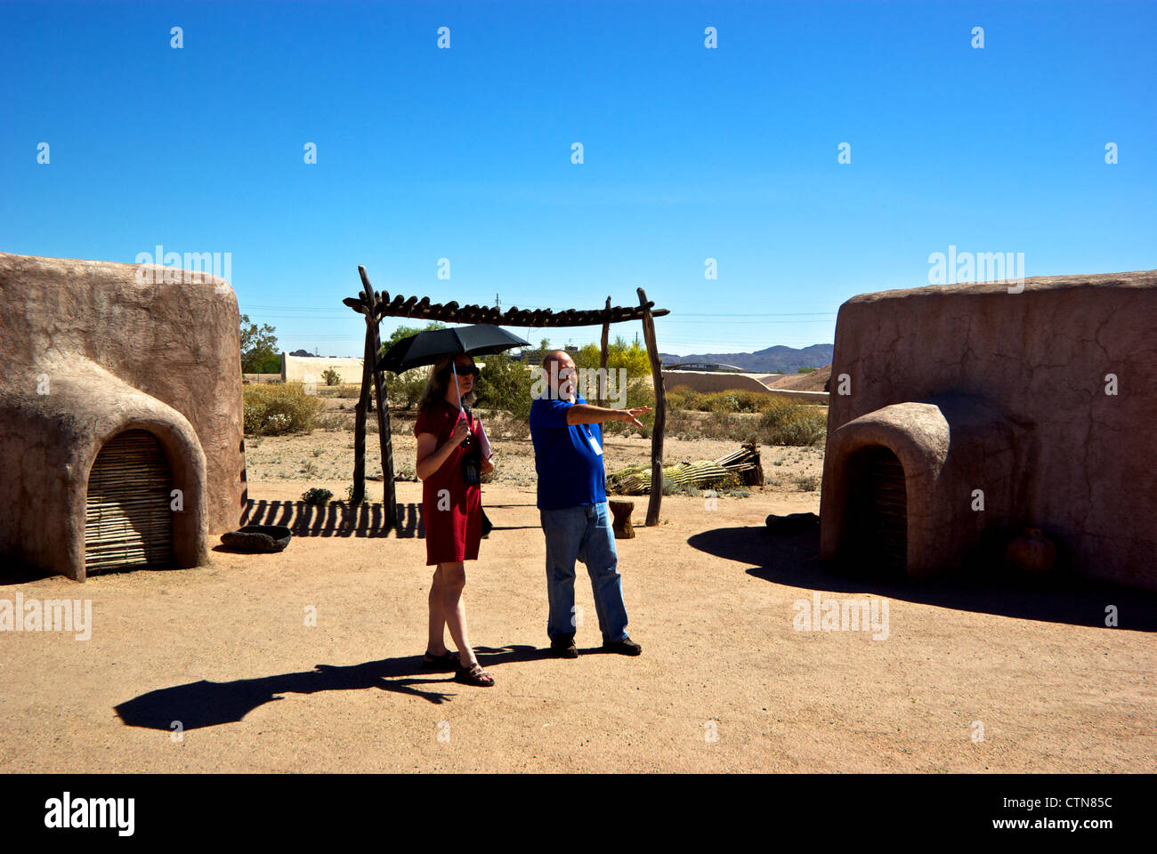 Docent showing visitor recreation of Arizona First Nations homes Pueblo Grande Museum Stock Photo