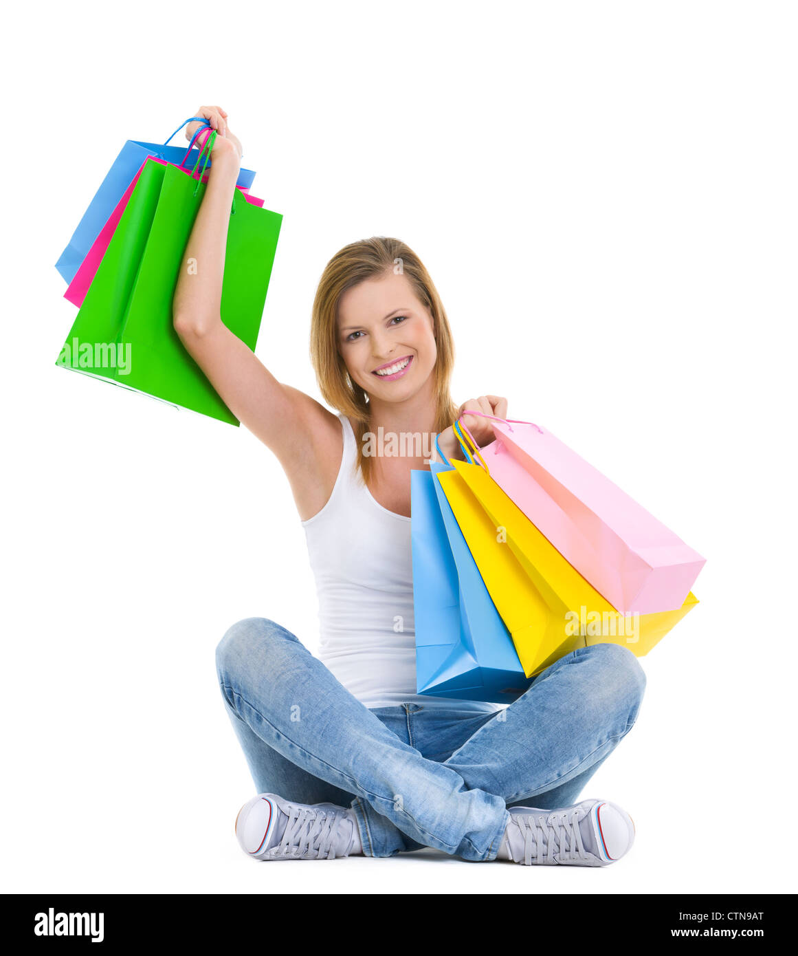 Full length portrait of happy teenage girl sitting with shopping bags Stock Photo