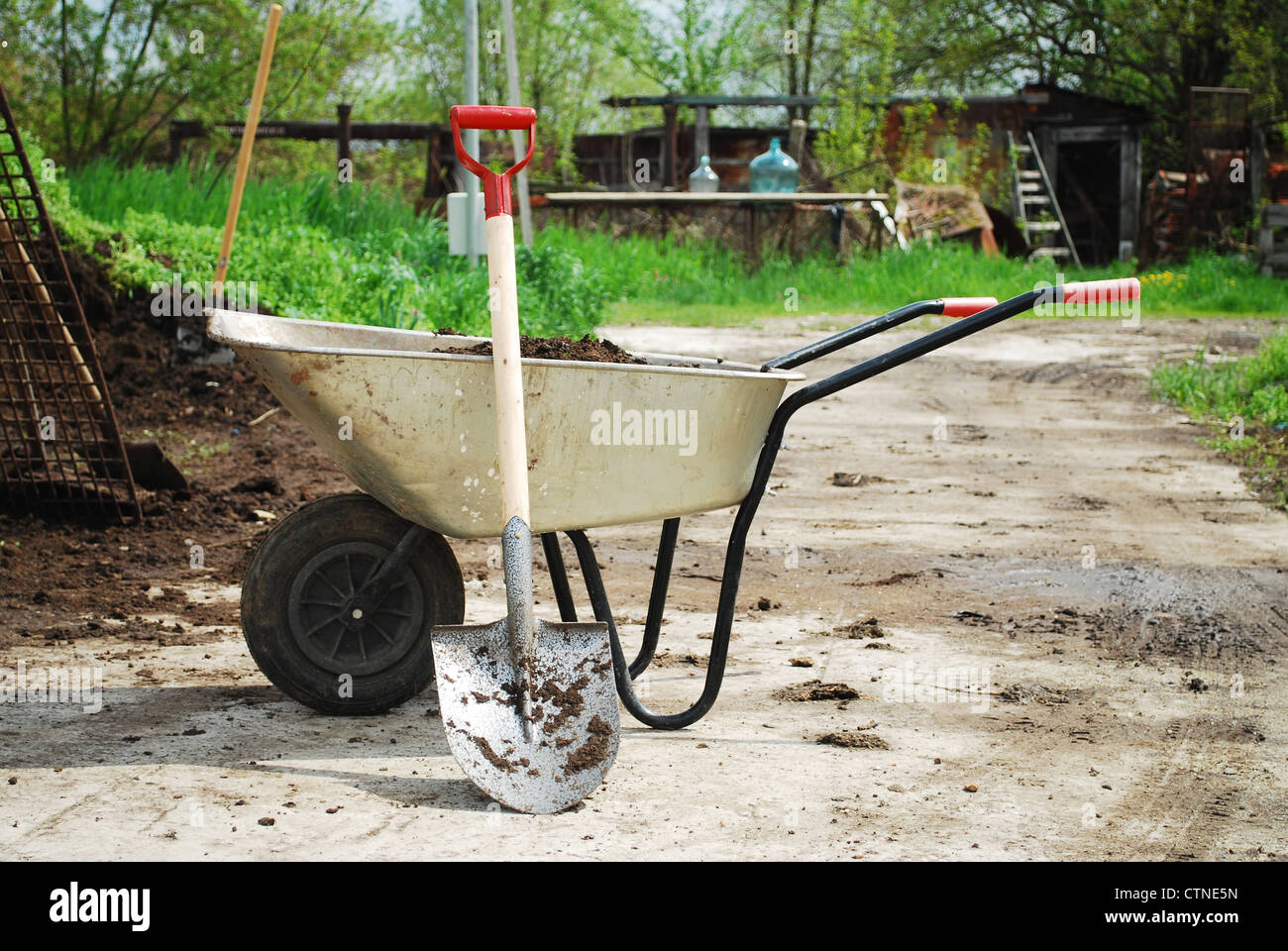 wheel barrow on the land at the county with land and shovel Stock Photo
