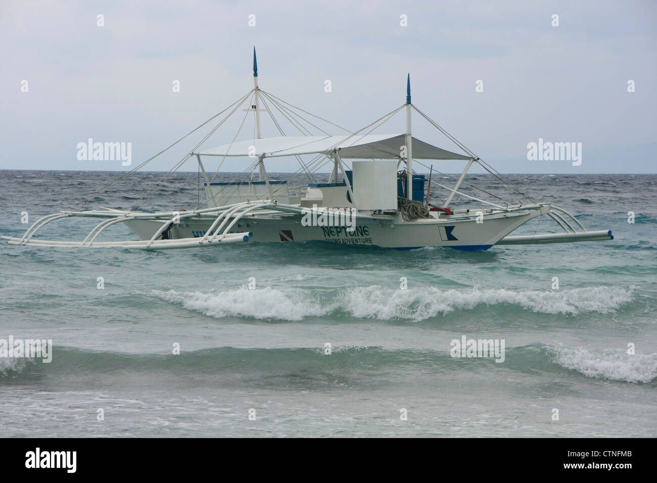 Outrigger boat in a stormy sea, Philippines Stock Photo