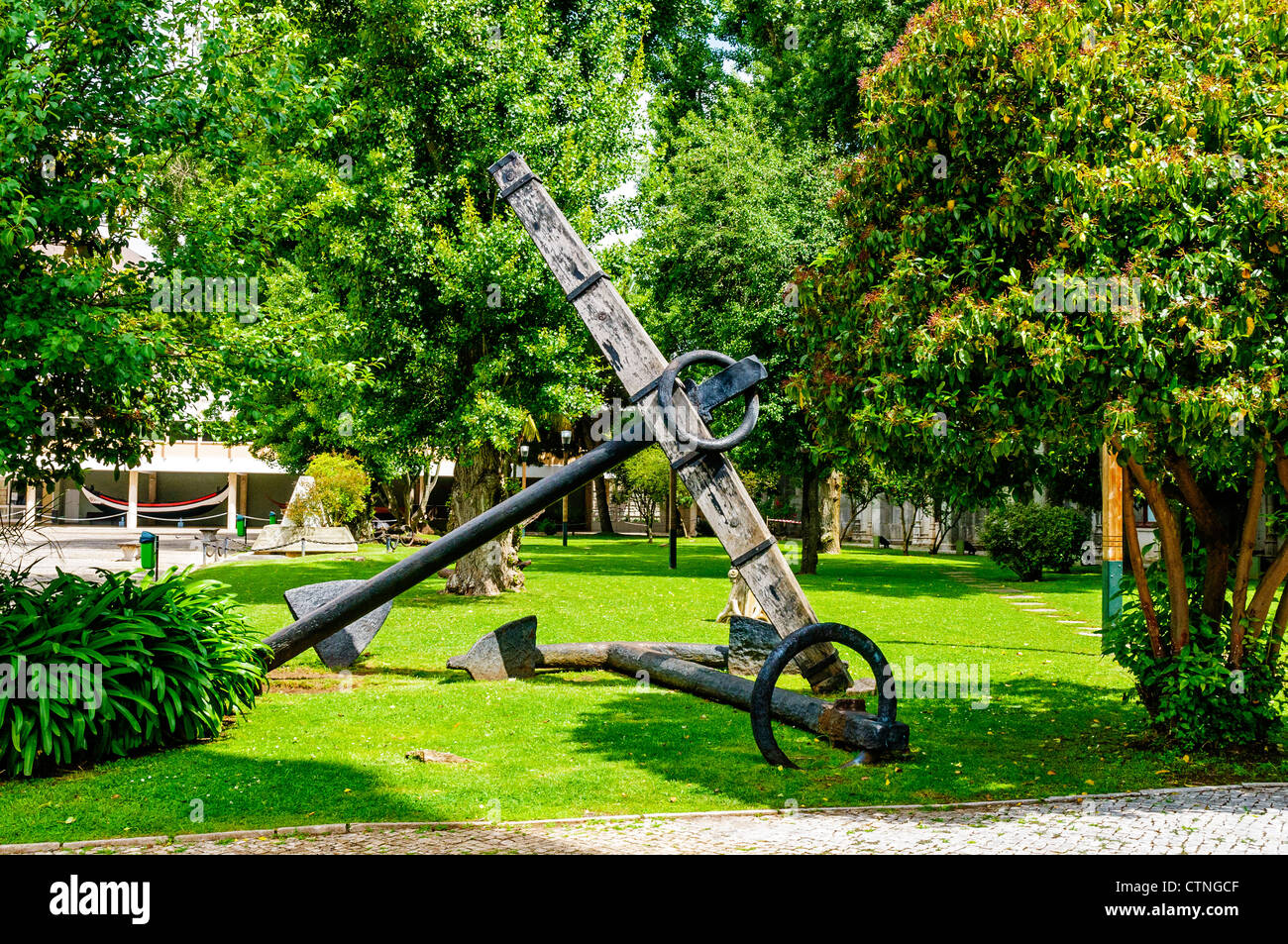 Two large black iron ships anchors attractively situated on the lawn in front of one of the halls of the Maritime Museum, Lisbon Stock Photo